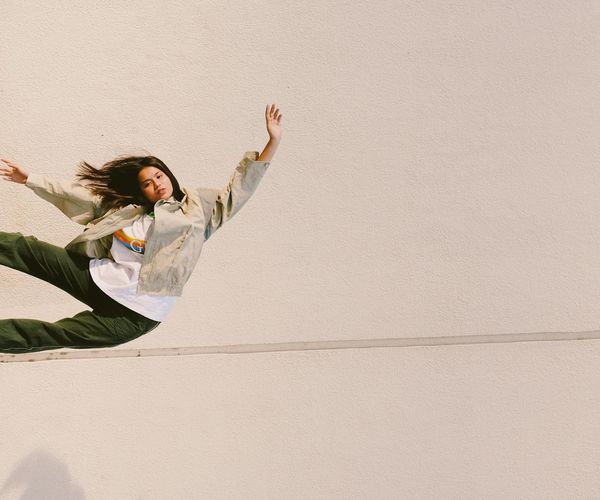 Person in a balancing pose against a serene background.